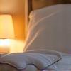 A serene bedroom scene with a sleep mask and diffuse lighting